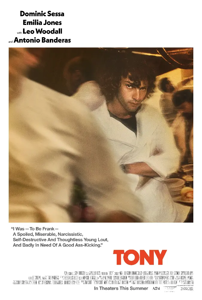 Movie poster for “TONY” featuring a young man with curly dark hair in a white robe standing with his arms crossed in a warmly lit room while blurred figures move around him. Text on the poster reads “Dominic Sessa Emilia Jones with Leo Woodall and Antonio Banderas” and “I Was To Be Frank A Spoiled Miserable Narcissistic Self Destructive And Thoughtless Young Lout And Badly In Need Of A Good Ass Kicking.” The title “TONY” appears in large red letters above the text “In Theaters This Summer.”